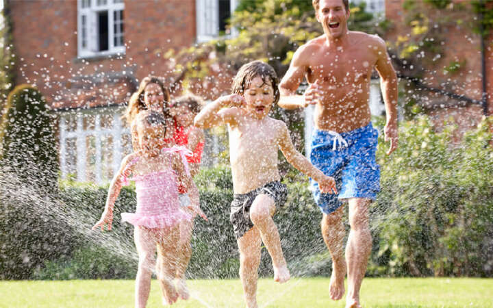 familie im garten rennt unterm wasser spaß 800x500